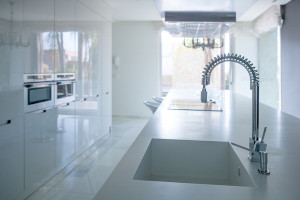 Modern white kitchen perspective with integrated bench sink and spring faucet